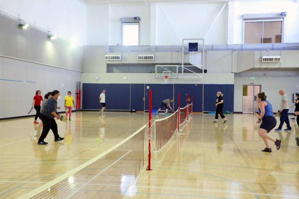 10 people playing pickleball on three courts in Carver Gym
