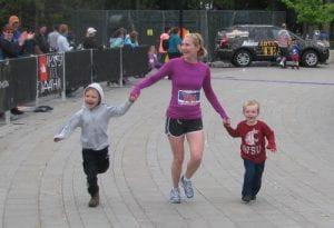 Amber Asbjornsen is joined by her two sons as she crosses the finish line of her 1st half marathon in Whistler 