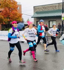 group of 4 women runners in brightly colored hats at Bellingham Bay Marathon