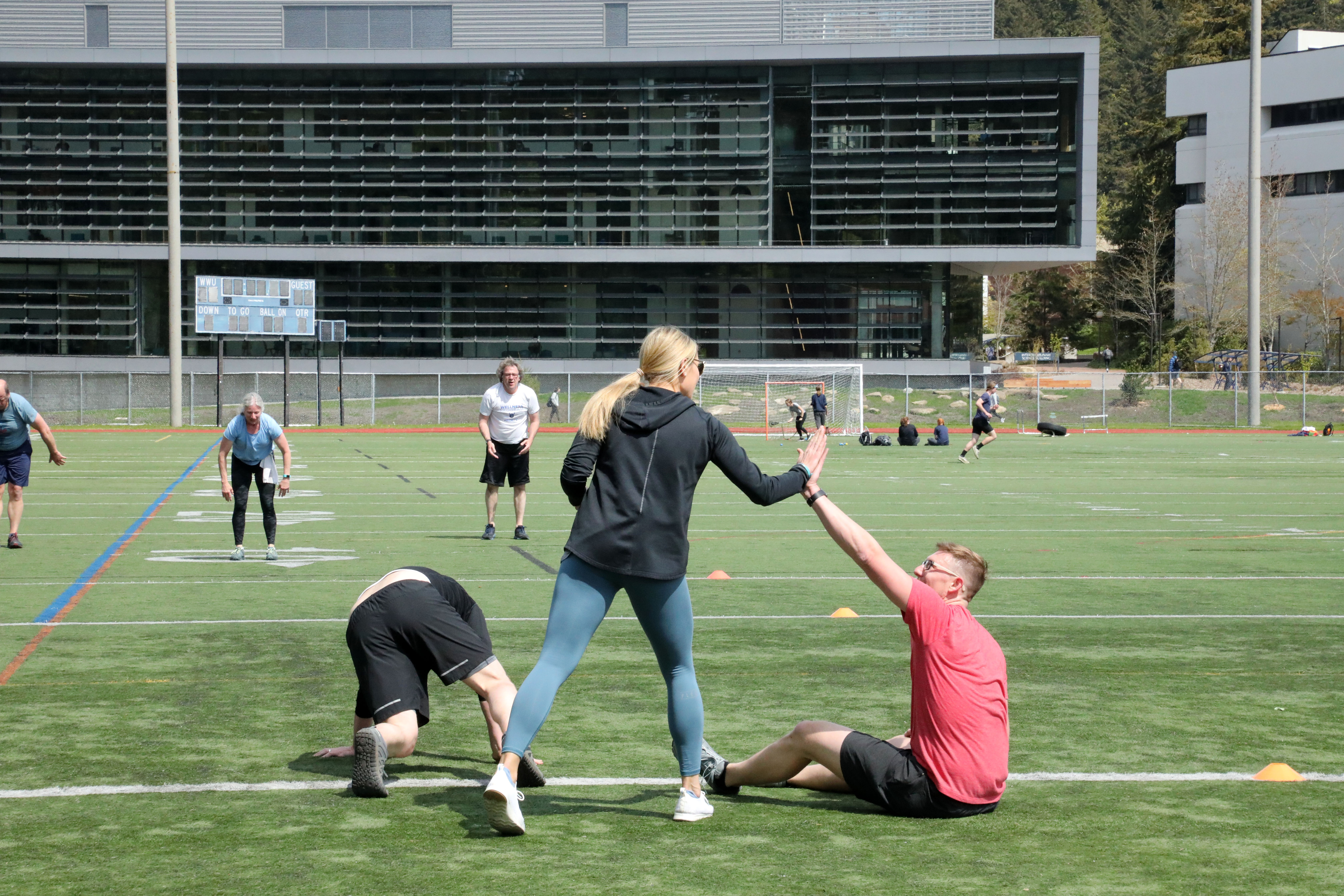 two people high-fiving during a workout class on the WWU track field
