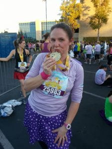 Jeniene Bengtsson in a purple shirt holding a medal for the Tinkerbell 10K at Disneyland