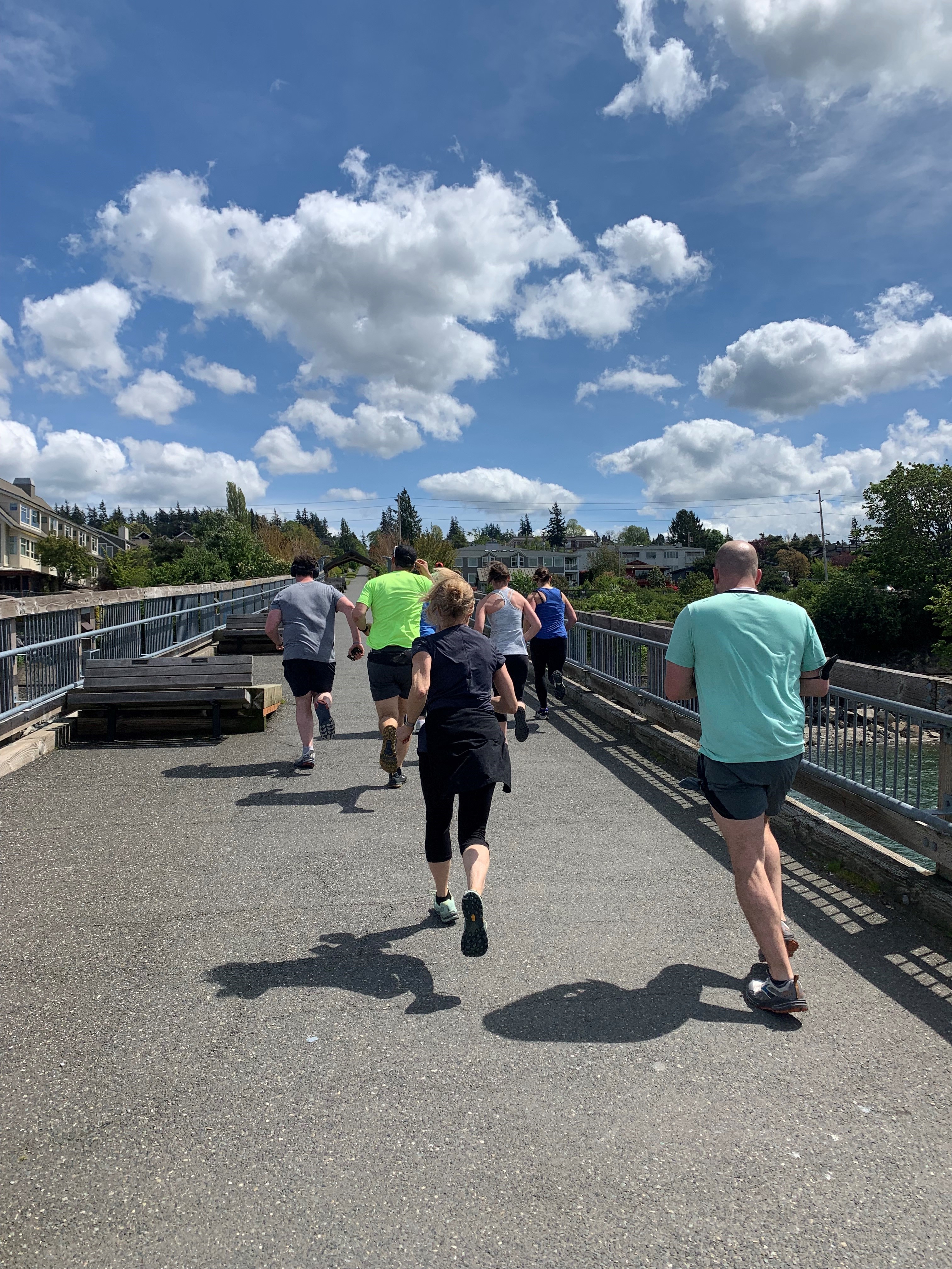 group of people running outside over the Taylor Street bridge