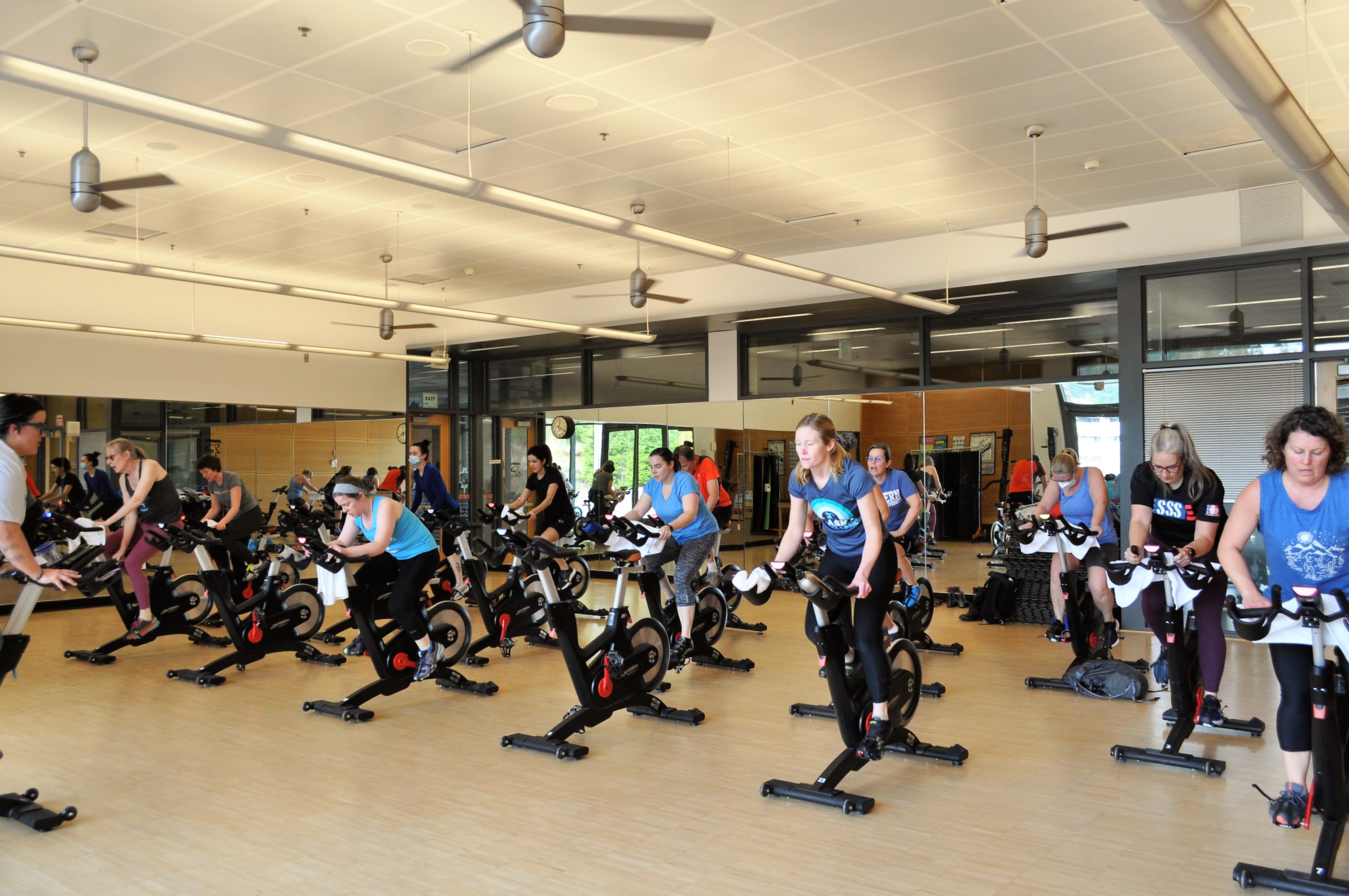 large group of patrons on spin bikes in a fitness studio in the WWU Rec Center