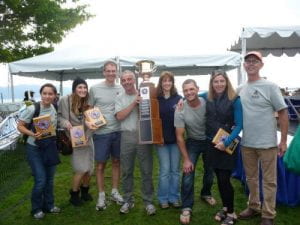 Aven Construction team at the 2013 Ski to Sea race holding up a large trophy and 4 awards on plaques