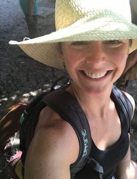 Kate backpacking with a straw hat and black tank top on