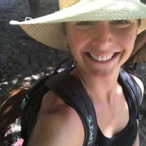 Kate backpacking with a straw hat and black tank top on